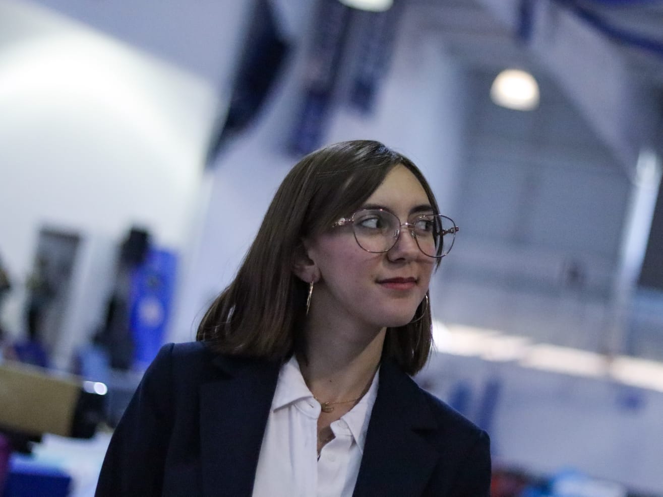 Daniela del Río con saco y lentes en la mesa de jueces de una competencia